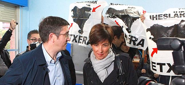 Un grupo de personas recibe con carteles de presos de ETA al lehendakari y su esposa.