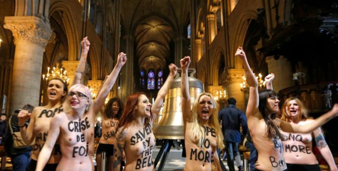 Feministas semidesnudas en el interior de una iglesia.
