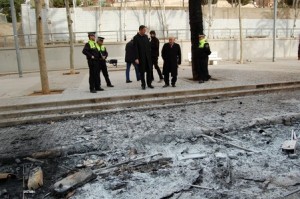 El alcalde Xavier Garcia Albiol, rodeado de agentes de la policía local, ante restos de contenedores quemados. 