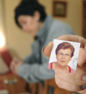 Una de las hijas de la fallecida muestra una foto de su madre, en presencia de su hermana.