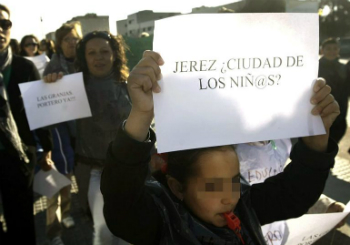 Una niña del colegio "Las Granjas" de Jerez de la Frontera (Cádiz) acompañada por sus padres, lleva un cártel de protesta durante la manifestación que bajo el lema "La Educación no es basura".