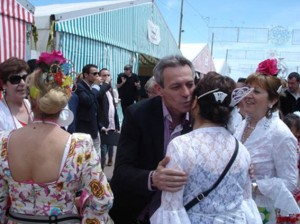 Anglada saluda a un grupo de mujeres bellamente ataviadas con trajes de faralaes.