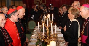 El arzobispo de Barcelona, de rojo, entre los prelados que agasajan a la ex vicepresidenta del Gobierno de Zapatero, María Teresa Fernández de la Vega.