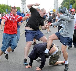 Aficionados polacos golpean en el suelo a un seguidor ruso.