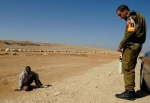 Un soldado israelí monta guardia ante refugiado sudanés, cerca de la frontera con Egipto.