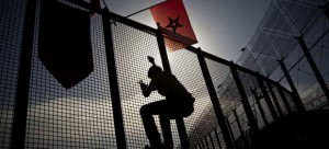 Un joven marroquí trepa en la verja de la frontera entre Marruecos y Melilla. Un joven marroquí trepa en la verja de la frontera entre Marruecos y Melilla.