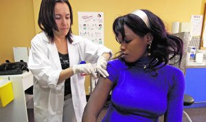 Una médico pone una inyección a una mujer subsahariana.