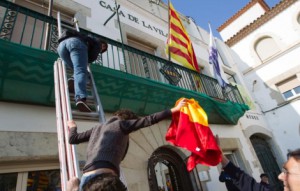 Un grupo de delincuentes separatistas retira una bandera de española del balcón de un Ayuntamiento catalán.