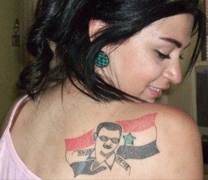 Una mujer siria, con un tatuaje del presidente Al Assad en su espalda.