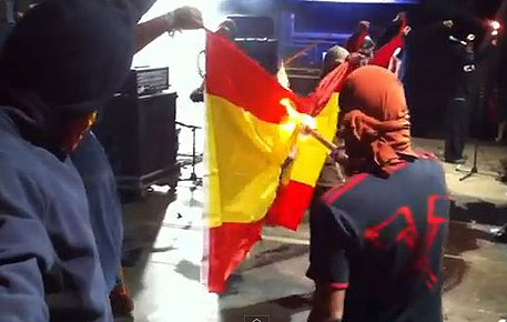 Separatistas catalanes se disponen a quemar una bandera de España.