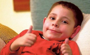 Edu, siempre sonriente y luchador, levanta los pulgares de sus dedos en señal de victoria.