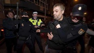 El hombre que llevaba el líquido inflamable, retenido por policías.