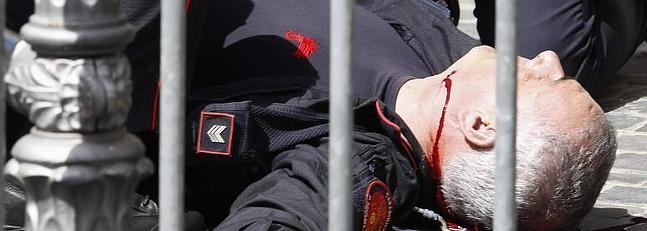 Uno de los 'carabinieri' heridos yace en el suelo.