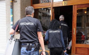 Ertzainas de la Policía Científica entran en el portal.
