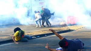 Río de Janeiro. Manifestantes se protegen del gas lacrimógeno fuera del Estadio Maracaná este 16 de junio.