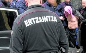 Agentes de la Ertzaintza sacan al detenido del gimnasio, donde hallaron a la mujer en parada cardiorrespiratoria. 