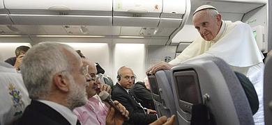 Francisco escucha la pregunta de uno de los periodistas en el avión que le traslada a Italia.