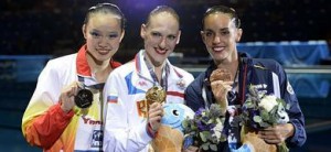 Carbonell (d), muestra su medalla de bronce junto a Huang (i) y Romashina.