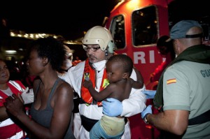 Un miembro de Cruz Roja con un niño en brazos. 