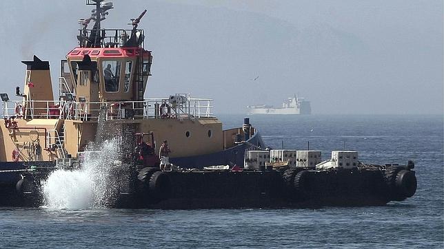 Un remolcador de Gibraltar lanzando al mar bloques de hormigón con pinchos en la zona