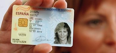 Una mujer muestra su DNI de nacionalidad española.