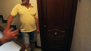 Un vecino junto a la puerta de la vivienda donde se cometió el delito.