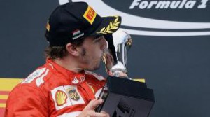 Alonso besa su trofeo en el podio de Hungría. 