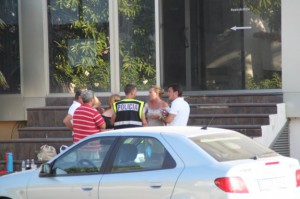 Un agente de la Policía Nacional habla con varias personas que se encontraban en la urbanización.