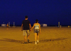 Una pareja se interna en la playa de la Malvarrosa.