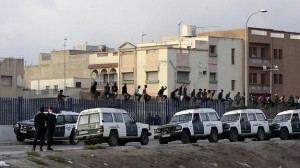 Inmigrantes encaramados en la parte alta de la valla de Melilla. 