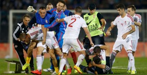 Varios jugadores de Albania y Serbia se pelean sobre el césped. 