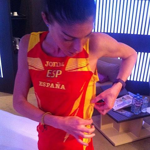 Cristina González se ajusta la camiseta de uno de sus compañeros para la carrera