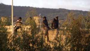 Una treintena de subsaharianos permanecen encaramados en lo alto de la verja.