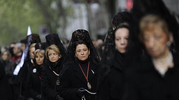 Mujeres, con la tradicional matilla negra, participan en una procesión.