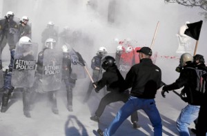 Manifestantes antisistema griegos luchan con la policía antidisturbios durante una protesta
