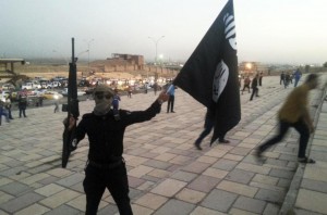 Un combatiente del Estado Islámico agita su bandera en Mosul.