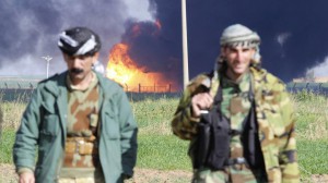 Dos peshmergas, ante un campo de petróleo en Kirkuk (Irak), cuya producción tuvo que suspenderse por los ataques del Estado Islámico
