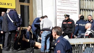 Uno de los heridos en el tiroteo, atendido a las puertas del Palacio de Justicia de Milán