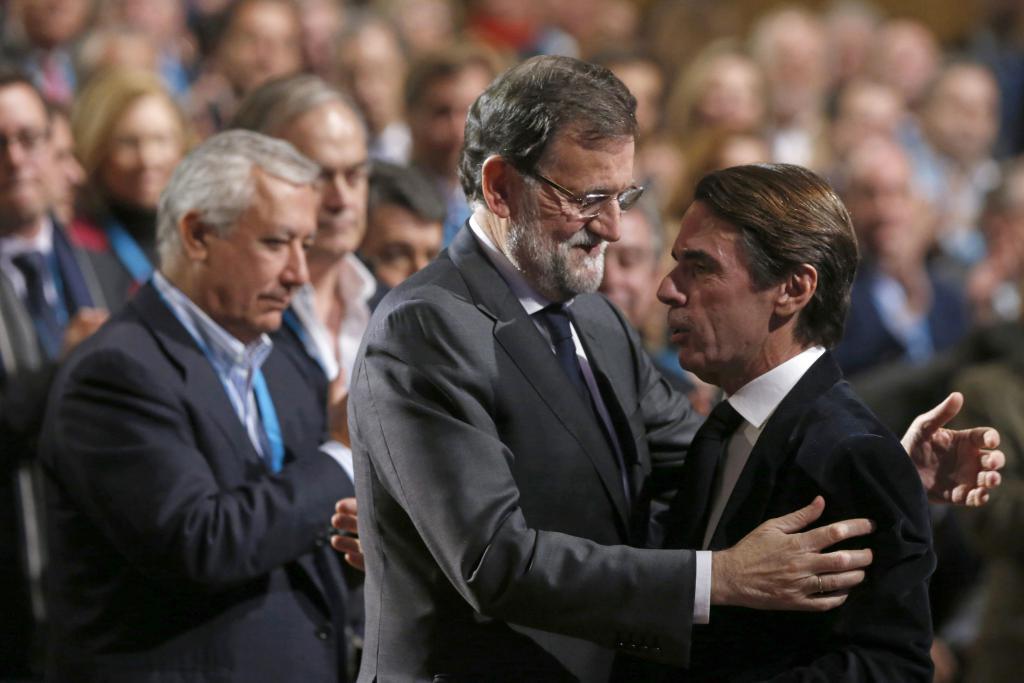 El presidente del Gobierno y del PP, Mariano Rajoy (i), saluda al presidente de honor del PP y expresidente del Ejecutivo, José María Aznar (d)