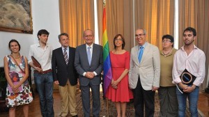 El alcalde de Málaga, Francisco de la Torre (cuarto por la izquierda), posa junto a una bandera del movimiento gay. A su izquierda, la candidata socialista, María Gámez.