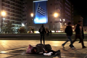 Pobreza frente a un cartel que pone "Grecia, te quiero".
