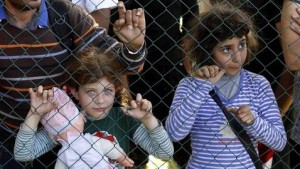 Niñas refugiadas esperando pasar la frontera