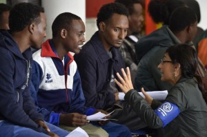 Un miembro de la Organización Internacional para las Migraciones (OIM) habla con un grupo de refugiados eritreos antes de viajar a Suecia.