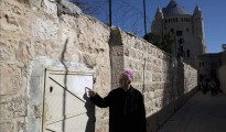 Un monje señala hoy un graffiti cerca de la Abadía de la Dormición, en la Ciudad Vieja de Jerusalén.