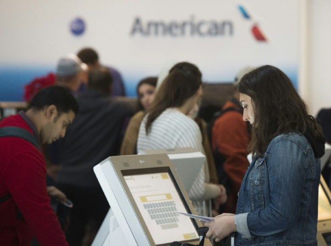 Pasajeros verifican sus vuelos de American Airlines el 23 de diciembre de 2015 en Arlington, Estados Unidos