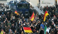 Un camión de la policia antidisturbios dispersa con chorros de agua una manifestación convocada en Colonia por el movimiento Pegida
