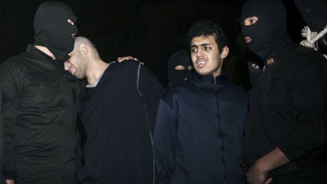 Alireza Mafiha (segundo de la izquierda) inclina su cabeza en el hombro de un oficial de seguridad momentos antes de su ejecución, junto con Mohammad Ali Sarvari (segundo de la derecha) en Teherán, el domingo 20 de enero de 2013