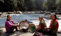 Tres jóvenes de la tribu matrilineal Khasi descansan tras lavar la ropa en el río en el estado de Meghalaya, en el noreste de la India.
