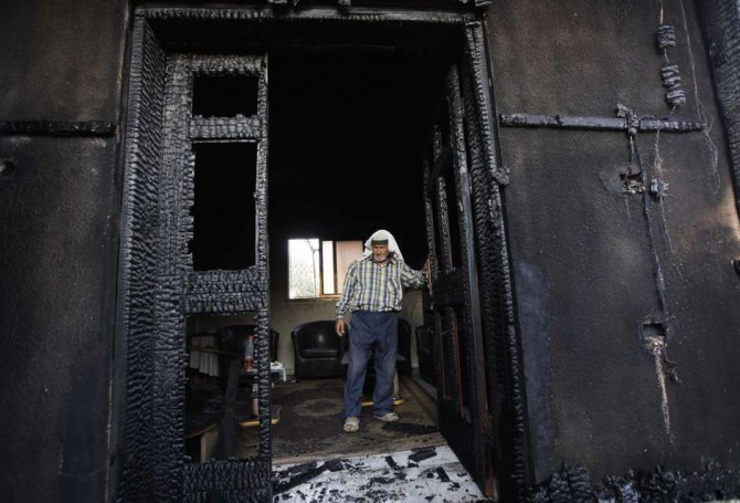 En esta imagen de archivo del 31 de julio de 2015, un palestino examina una casa incendiada en un supuesto ataque de colonos judíos, y que mató a un niño palestino de 18 meses y a sus padres, en el pueblo de Duma, cerca de la ciudad cisjordana de Nablús. 