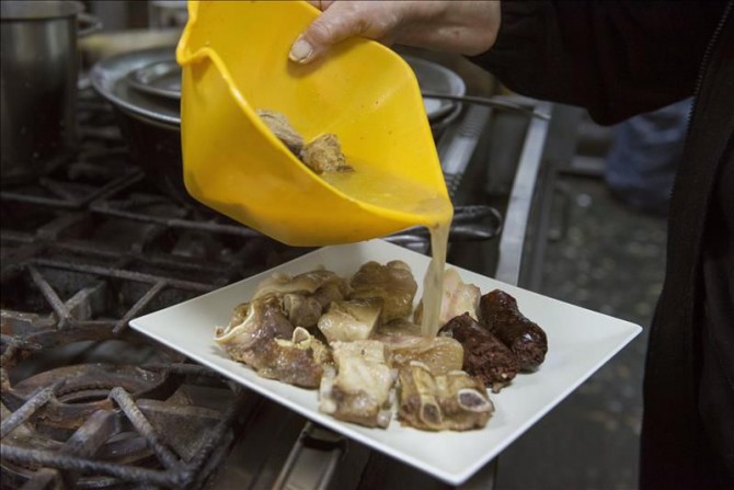 Elaboración en un restaurante de Granada de la olla de San Antón una plato típico de Andalucía Oriental con gran arraigo en la capital granadina que suma el beneplácito del santo para perdonar los excesos.